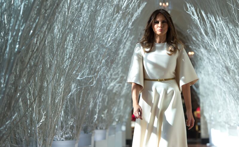 US First Lady Melania Trump walks through Christmas decorations in the East Wing as she tours holiday decorations at the White House in Washington, DC, on November 27, 2017.