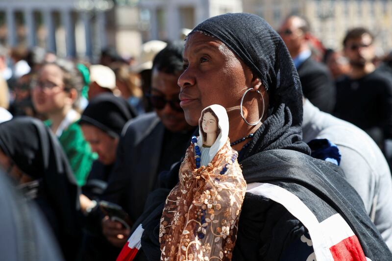 A woman holds a statue of a Madonna as people attend the funeral Mass of Pope Francis in St. Peter's Square, at the Vatican, April 26, 2025.