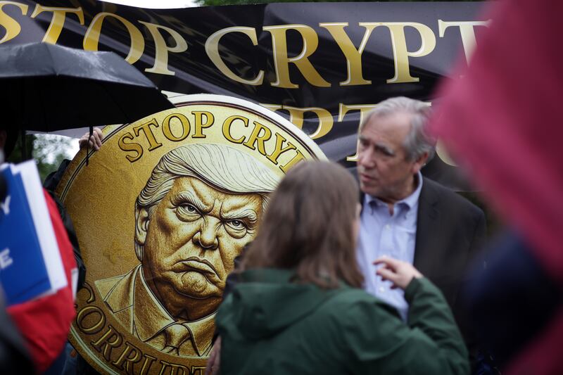 STERLING, VIRGINIA - MAY 22:  Demonstrators protest outside Trump National Golf Club where a private dinner is hosted by U.S. President Donald Trump on May 22, 2025 in Sterling, Virginia. Activists staged an “America Is Not For Sale” protest while President Trump hosted the buyers of his cryptocurrency “meme coin” at the golf club.  (Photo by Alex Wong/Getty Images)