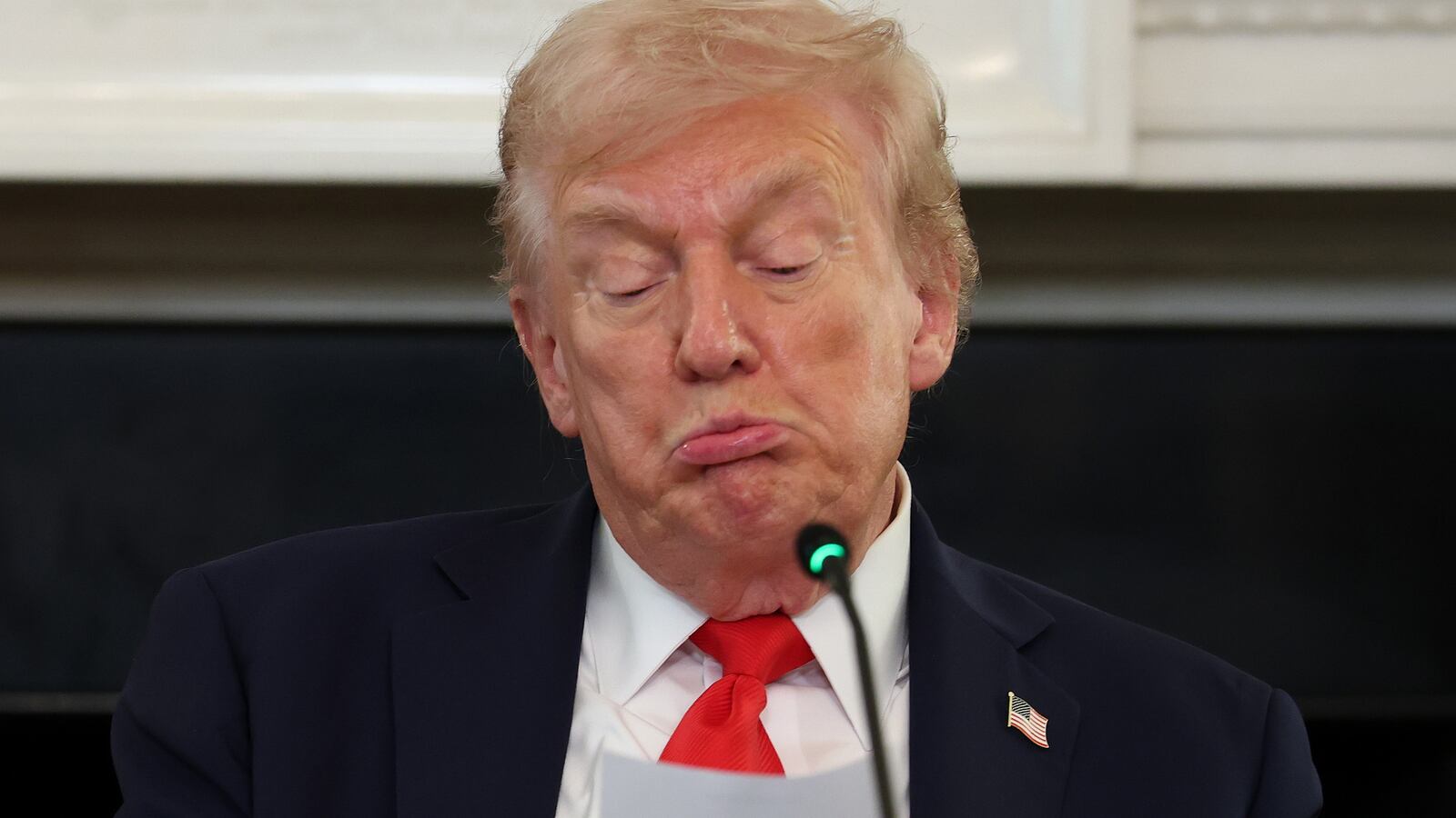 President Donald Trump reads a note in the State Dining Room of the White House on October 08, 2025 in Washington, DC.