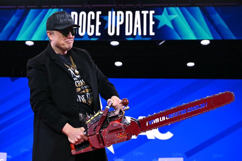 Elon Musk holds a chainsaw reading "Long live freedom, damn it" during the annual Conservative Political Action Conference (CPAC) at the Gaylord National Resort & Convention Center at National Harbor in Oxon Hill, Maryland, on February 20, 2025. The chainsaw was a present to Elon Musk from Argentina's President Javier Milei.