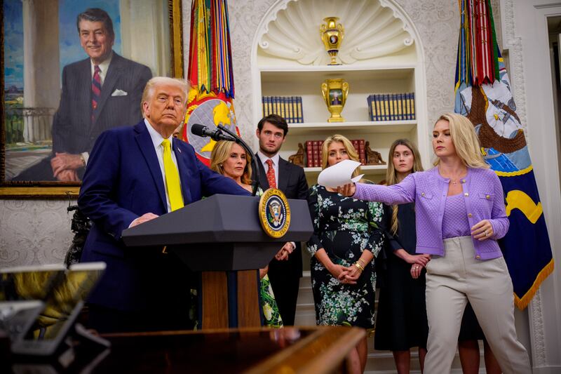 WASHINGTON, DC - APRIL 18: White House press secretary Karoline Leavitt (R) hands U.S. President Donald Trump a document as he speaks during a swearing in ceremony for Dr. Mehmet Oz as Medicare and Medicaid Services Administrator in the Oval Office at the White House on April 18, 2025 in Washington, DC. Oz spoke of a desire to provide America access to great care while reducing chronic disease and modernizing Medicare and Medicaid. (Photo by Andrew Harnik/Getty Images)