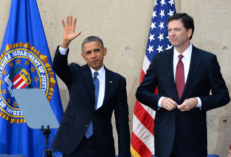 US President Barack Obama (L) waves as new Federal Bureau of Investigation (FBI) director James Comey looks on after an installation ceremony at the FBI headquarters in Washington, DC, on October 28, 2013. Comey was a top Justice Department official in the Bush administration and took over last month for Robert Mueller, who stepped down after 12 years of heading the agency. AFP Photo/Jewel Samad        (Photo credit should read JEWEL SAMAD/AFP via Getty Images)