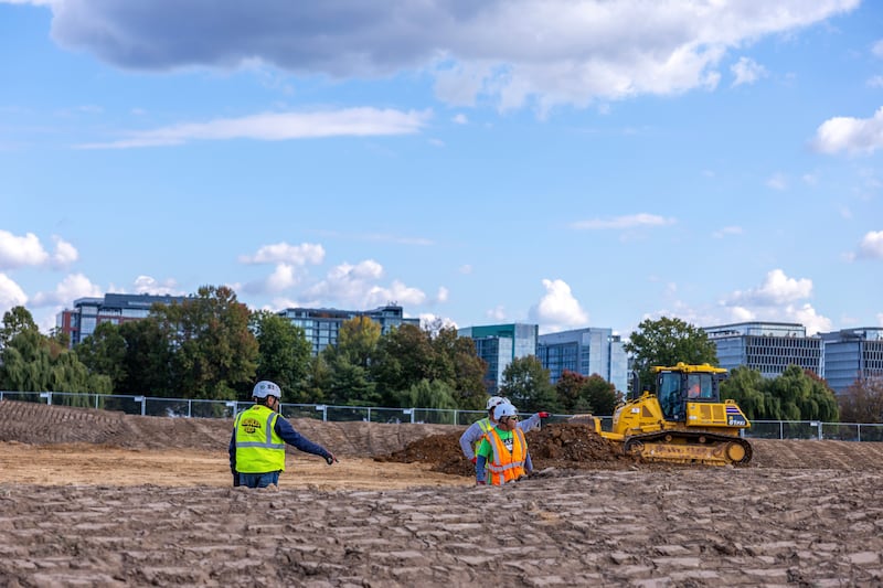WASHINGTON, DC - OCTOBER 24: Workers build a fence as trucks unload debris and soil from the demolition of the White House's East Wing at East Potomac Golf Course on October 24, 2025 in Washington, DC. The demolition is part of U.S. President Donald Trump's plan to build a multimillion-dollar ballroom on the eastern side of the White House. (Photo by Tasos Katopodis/Getty Images)