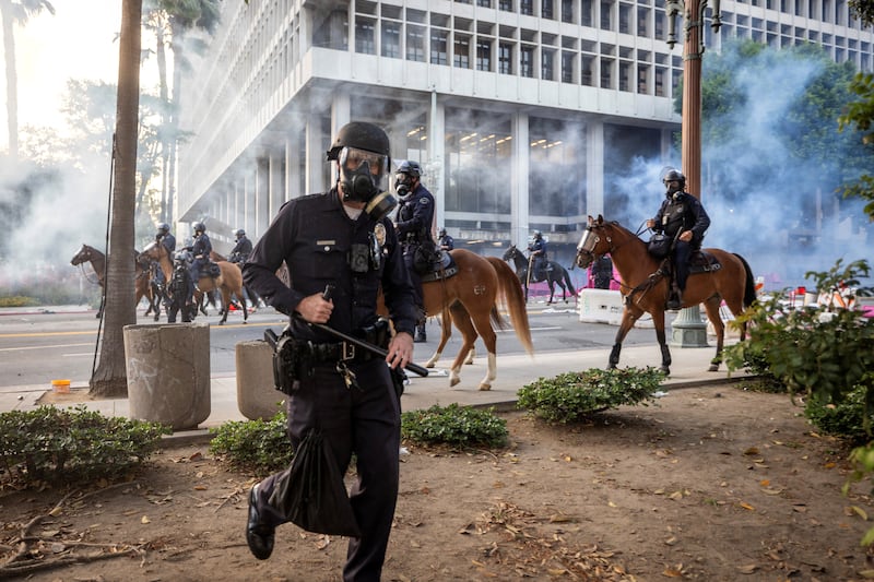 Los Angeles Police Department (LAPD) officers move in on demonstrators in front of LA City Hall during a protest against federal immigration sweeps in downtown Los Angeles, California