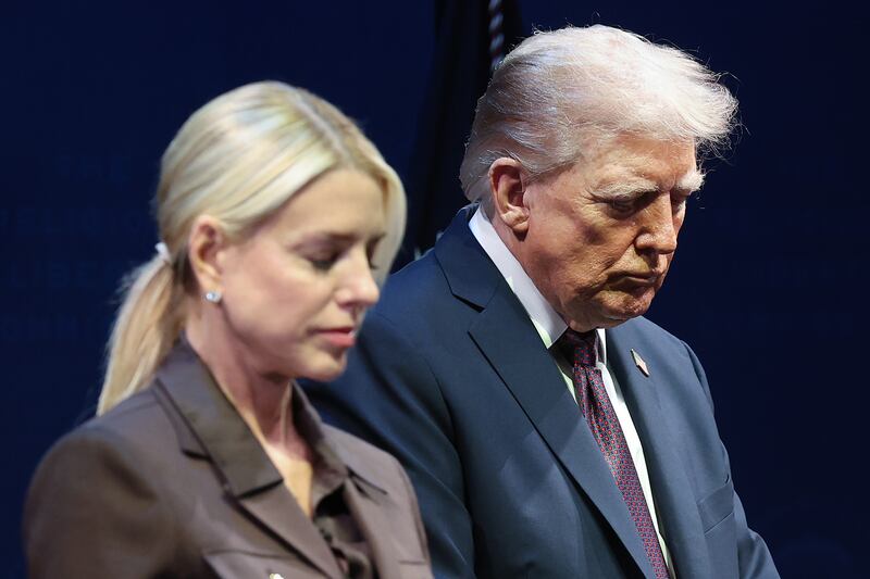 President Donald Trump bows his head in prayer with Attorney General Pam Bondi  at the Museum of the Bible.