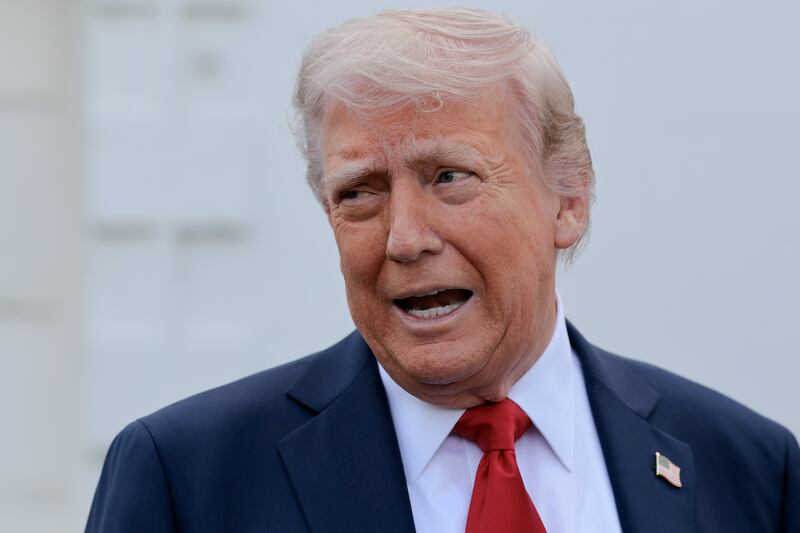 Trump looks with a frown and open mouth off to the left.