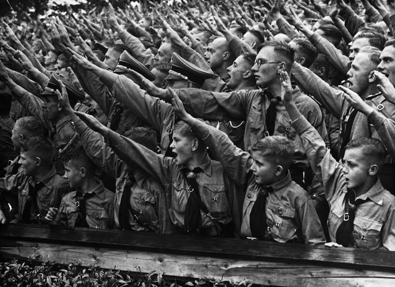 Crowds of Hitler Youth salute as they listen to a speech given by Adolf Hitler at a rally at Nuremberg Stadium in Germany, 1937.
