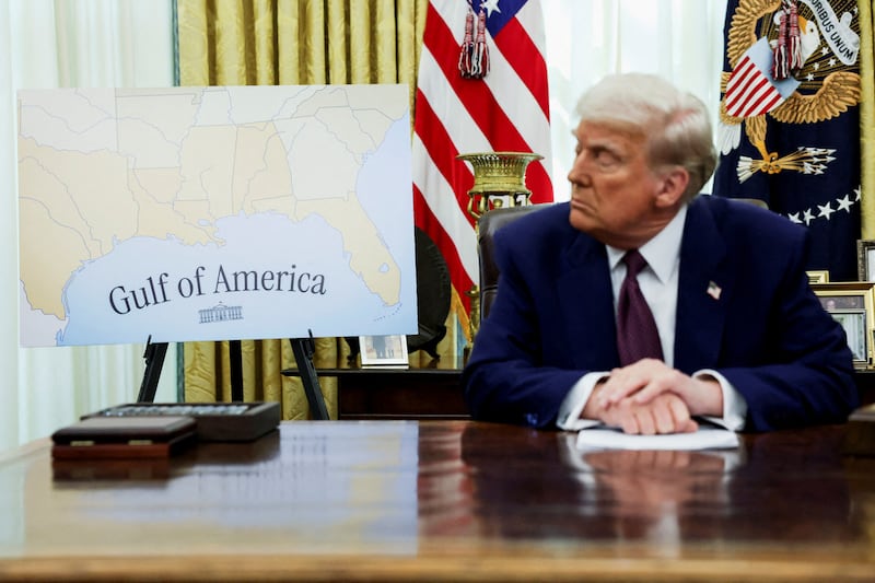 President Donald Trump sits next to a map that shows the Gulf of Mexico, which he renamed the Gulf of America, in the White House Oval Office in Washington, D.C. on February 13, 2025.