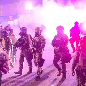 Federal law enforcement agents attack demonstrators protesting outside of an immigrant processing center with a barrage of tear gas and pepper balls
