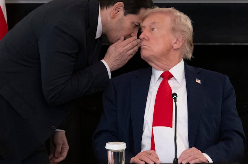Marco Rubio whispers to Donald Trump after handing him a note saying the Middle East peace deal is "very close" and asking him to “approve” a Truth Social post.