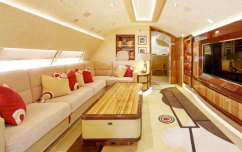 A living room on the upper deck features an L-shaped couch, built-in bookshelves, and built-in big-screen TV.