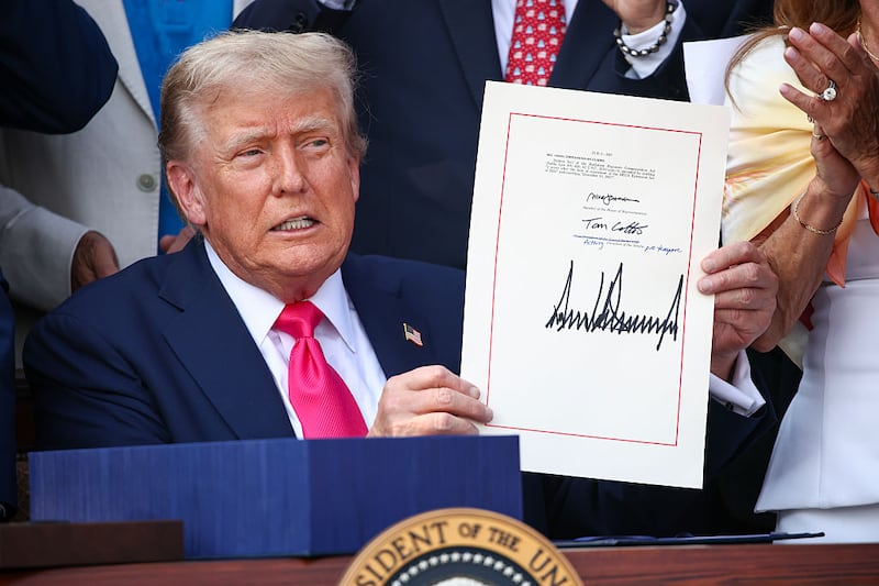 President Donald Trump, joined by Republican lawmakers, signs the One, Big Beautiful Bill Act into law during an Independence Day military family picnic on the South Lawn of the White House on July 04, 2025 in Washington, DC. After weeks of negotiations with Republican holdouts Congress passed the One, Big Beautiful Bill Act into law, President Trump’s signature tax and spending bill. The bill makes permanent President Donald Trump’s 2017 tax cuts, increase spending on defense and immigration enforcement and temporarily cut taxes on tips, while cutting funding for Medicaid, food assistance and other social safety net programs. (Photo by Samuel Corum/Getty Images)