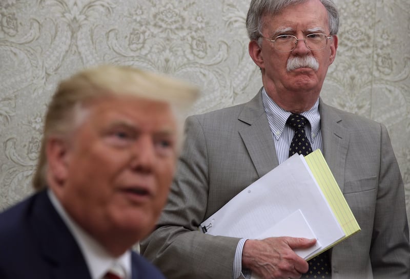 President Donald Trump speaks to members of the media as John Bolton listens in the Oval Office of the White House on August 20, 2019 in Washington, DC.