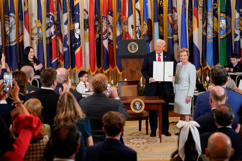 President Donald Trump stands with U.S. Secretary of Education Linda McMahon as he shows off an executive order to shut down the Department of Education at the White House in Washington, D.C. on March 20, 2025.