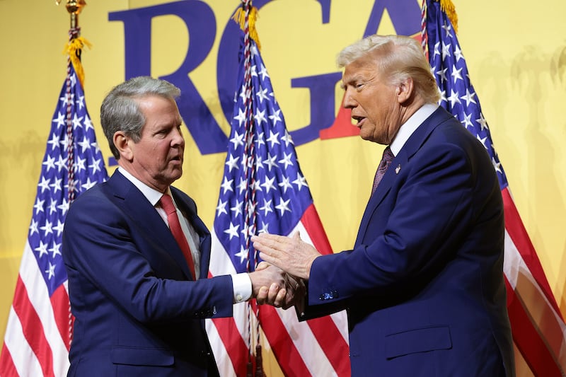 Trump and Kemp shake hands.