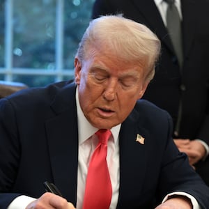 U.S. President Donald Trump signs an executive order in the Oval Office at the White House on February 25, 2025.