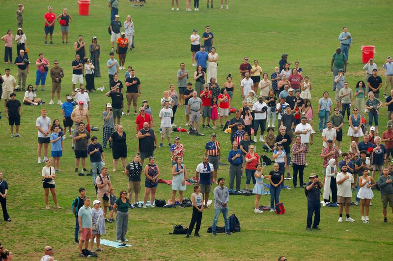 Attendees listen to the U.S. national anthem during the military parade commemorating the U.S. Army's 250th birthday in Washington, D.C., U.S., June 14, 2025.