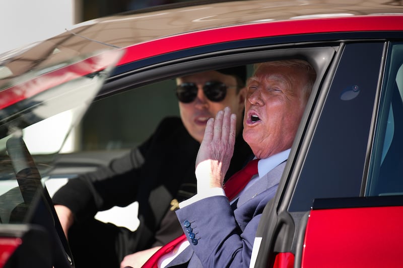 Donald Trump yells out from inside a Tesla.