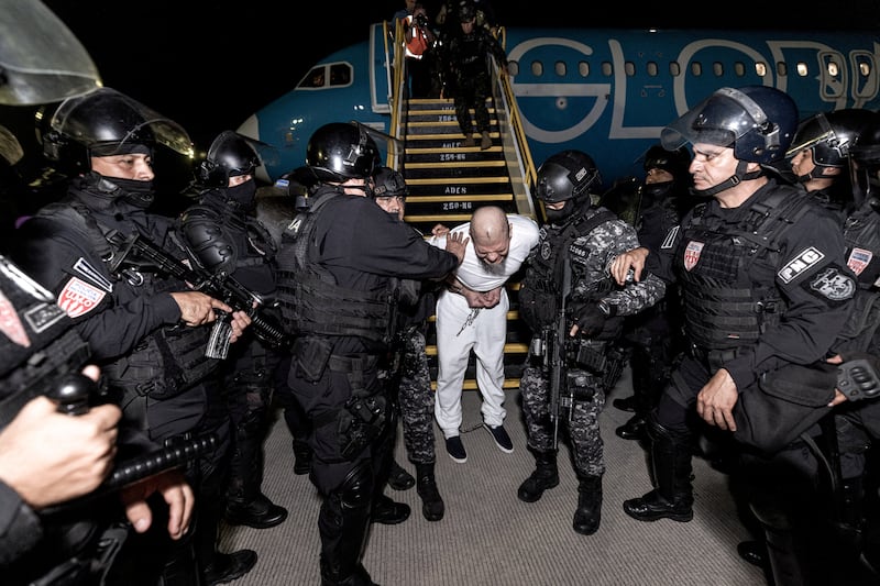 Salvadoran police officers escort alleged members of the Venezuelan gang Tren de Aragua recently deported by the U.S. government to be imprisoned in the Terrorism Confinement Center (CECOT) prison, as part of an agreement with the Salvadoran government, at the El Salvador International Airport in San Luis Talpa, El Salvador, in this handout image obtained March 16, 2025. Secretaria de Prensa de la Presidencia/Handout via REUTERS ATTENTION EDITORS - THIS IMAGE HAS BEEN SUPPLIED BY A THIRD PARTY. NO RESALES. NO ARCHIVES     TPX IMAGES OF THE DAY