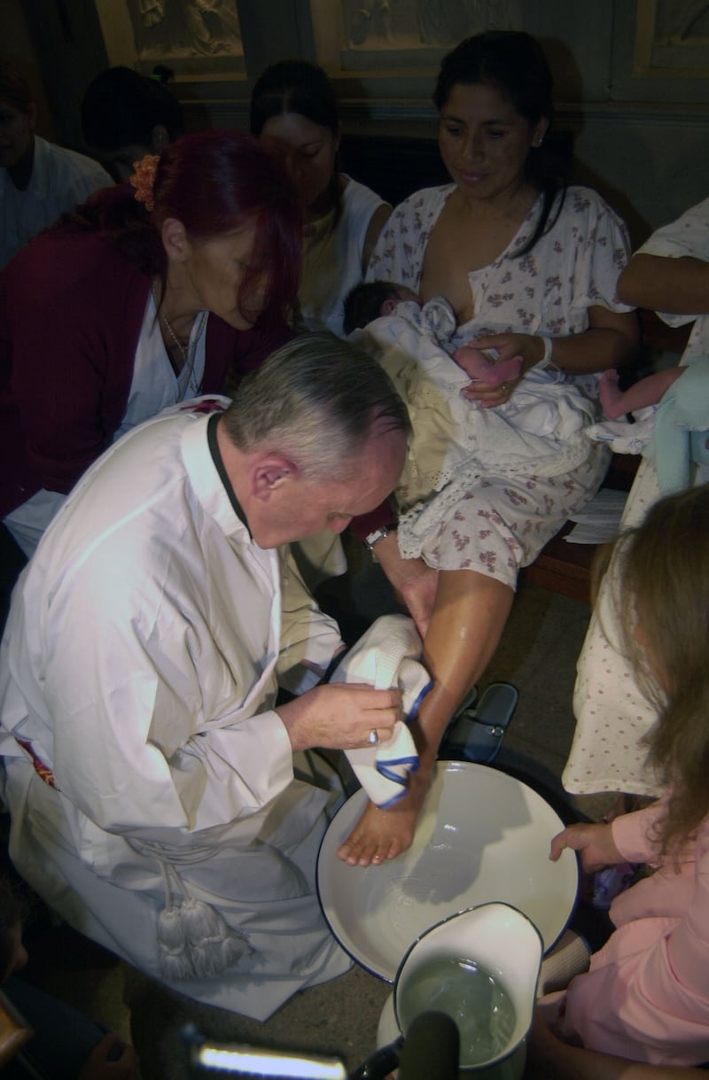 Pope Francis as then Archbishop of Buenos Aires, Jorge Bergoglio, performs a foot bath ceremony on a woman in Buenos Aires on March 24, 2005.