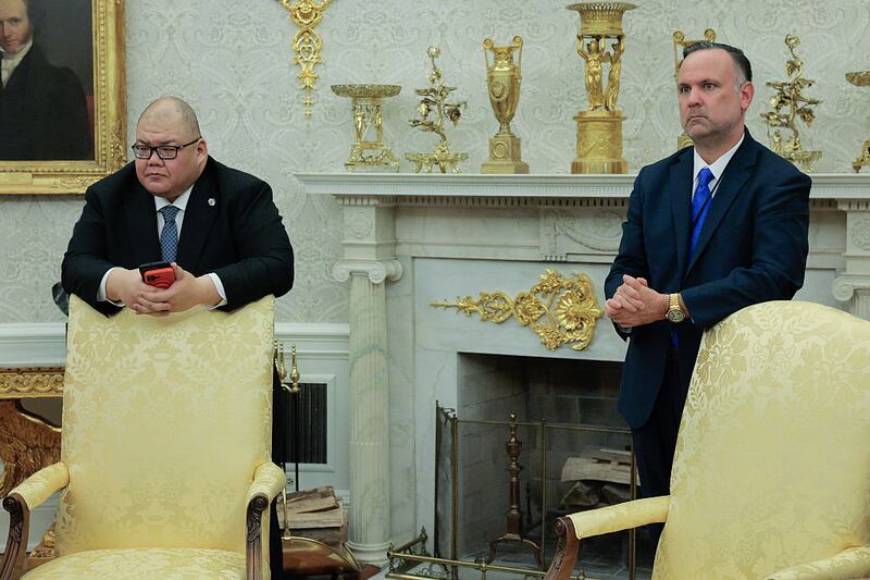 WASHINGTON, DC - APRIL 23: White House Communications Director Steven Cheung (L) and Deputy Chief of Staff Dan Scavino listen to U.S. President Donald Trump talk to reporters after signing executive orders in the Oval Office at the White House on April 23, 2025 in Washington, DC. Trump signed seven executive orders related to education policy. (Photo by Chip Somodevilla/Getty Images)