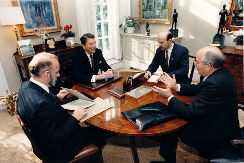 US President Ronald Reagan (1911 - 2004) (second left) and Soviet Chairman (or Premier) Mikhail Gorbachev (1931 - 2022) (right), along with unidentified others, talk in the White House's Oval Office study, Washington DC, December 9, 1987. (Photo by Bill Fitz-Patrick - White House via CNP/Getty Images)