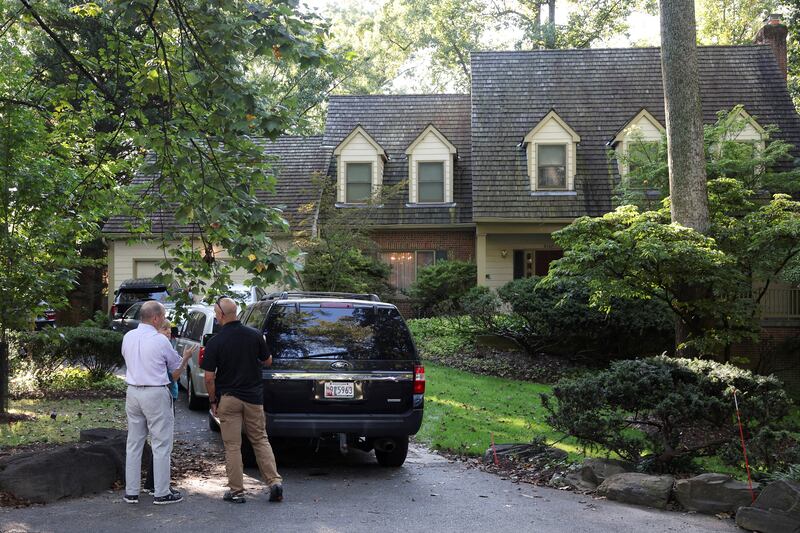 People stand outside the home of the former White House national security adviser John Bolton as it is searched by FBI members, in Bethesda, MD on August 22, 2025.