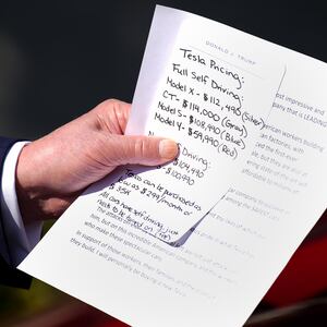Donald Trump carried a note that included Tesla pricing during his White House stunt where he purchased a new car he says he will never drive.