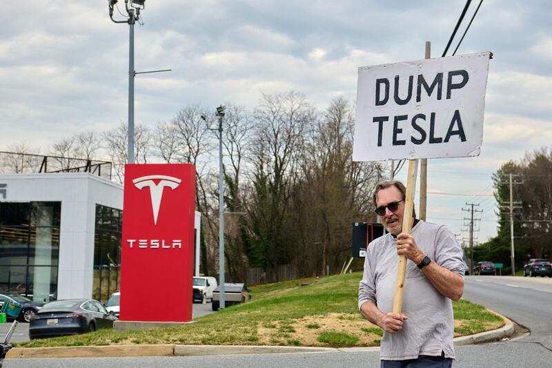 Baltimore area residents protest outside Tesla car dealership as part a boycott of Tesla vehicles on March 29, 2025.