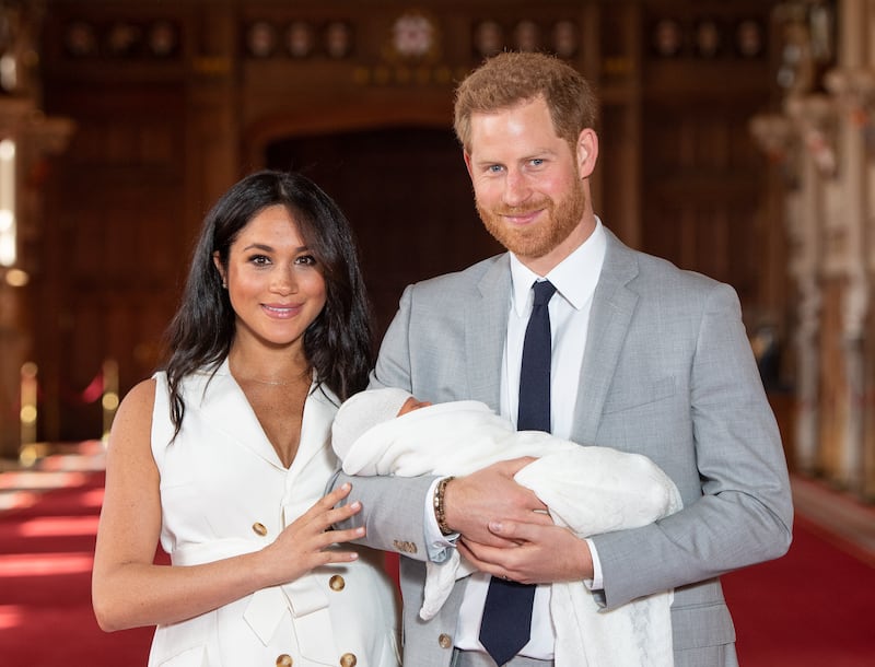 Meghan Markle and Prince Harry pose with their then-newborn son Archie Harrison Mountbatten-Windsor during a photocall in St George's Hall at Windsor Castle on May 8, 2019.