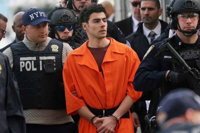 NEW YORK, NEW YORK - DECEMBER 19: Luigi Mangione, suspect in the killing of UnitedHealthcare CEO Brian Thompson in New York City, arrives at a heliport with members of the NYPD on December 19, 2024 in New York City.