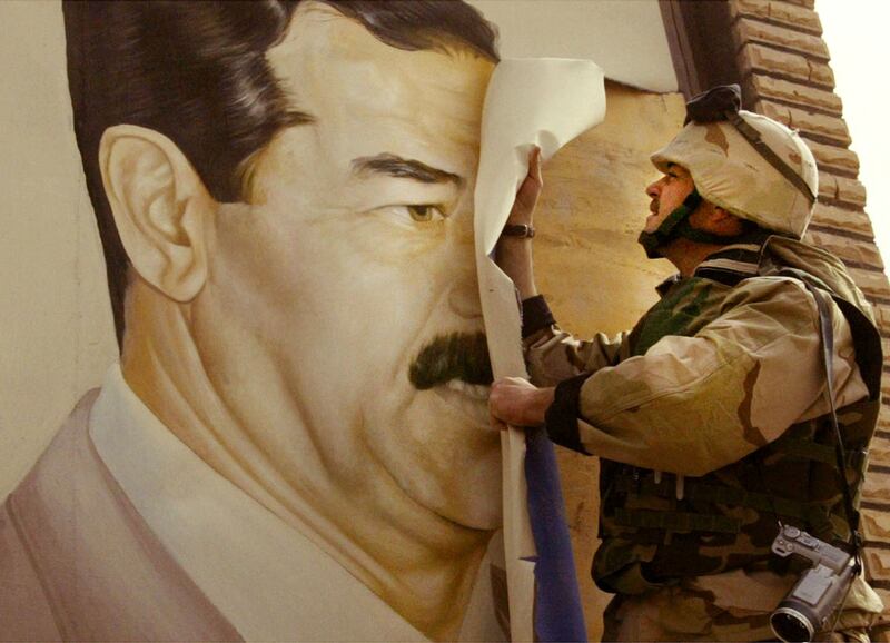 U.S. Marines pull down a poster of Saddam Hussein in Baghdad.