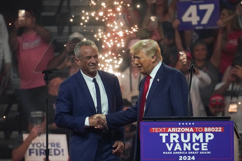 Donald Trump and Robert F. Kennedy Jr. shake hands on stage.
