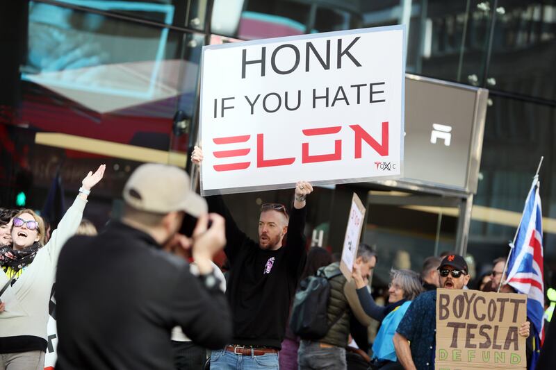 LONDON, ENGLAND - APRIL 5: Demonstrators rally against Tesla CEO Elon Musk, US President Donald Trump and their recent policies outside a Tesla showroom on April 05, 2025 in London, England. The London 'Hands Off' action group says that Donald Trump and Elon Musk think everything belongs to them and Londoners are fighting back! US citizens, Canadians, Brits, and people from all over the globe who've found a home in London are standing up for democracy. They believe that the US is threatening to invade Canada, Greenland, and Panama and are protesting as the Hands Off group in response. (Photo by Alishia Abodunde/Getty Images)