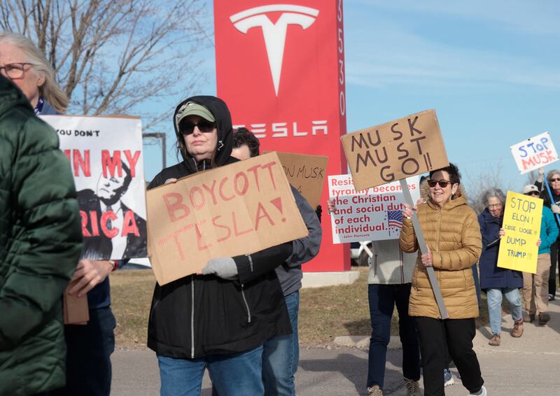 Demonstrators protest against Elon Musk in front of a Tesla dealership in Ann Arbor, Michigan on March 21, 2025.