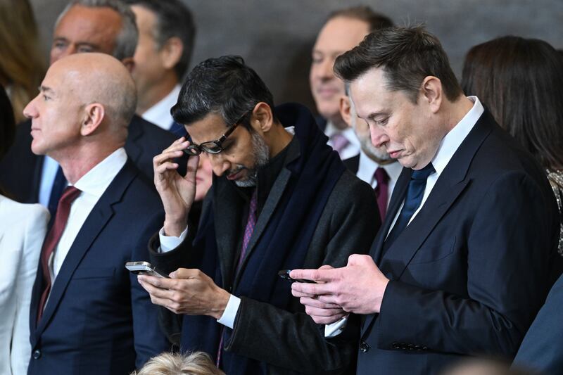 WASHINGTON, DC - JANUARY 20: (L-R) Amazon founder Jeff Bezos with Google CEO Sundar Pichai and Tesla and SpaceX CEO Elon Musk who are checking their phones