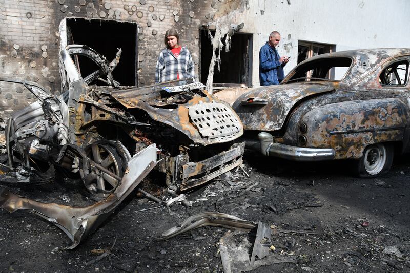 LVIV, UKRAINE - JULY 12: Locals stare on cars lying burned and wrecked at the site of a Russian drones' strike on the city's residential area on July 12, 2025 in Lviv, Ukraine. Overnight into July 12, the Russian army launched a combined strike on Ukrainian cities, using almost 600 drones and 26 missiles. In Lviv, the drones' attack resulted in damage to residential apartment buildings, two industrial enterprises, a preschool building, and dozens of cars. Nine people were injured, including two children. (Photo by Mykola Tys/Global Images Ukraine via Getty Images)