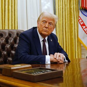 President Donald Trump speaks to reporters after signing a series of executive orders in the Oval Office of the White House on January 23.