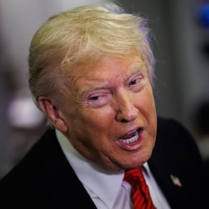 President Donald Trump speaks to reporters aboard Air Force One.