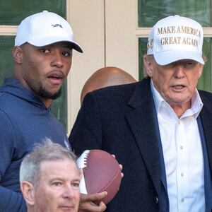 President Trump with his grandchild and Philadelphia Eagles football player Saquon Barkley.