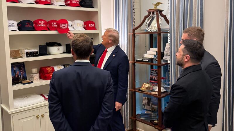 Trump shows Zelensky and Macron his trolling MAGA hat collection at Ukraine White House summit.
