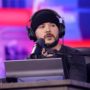 Tim Pool speaks into a microphone on stage at the 2024 AmericaFest at the Phoenix Convention Center in Arizona/