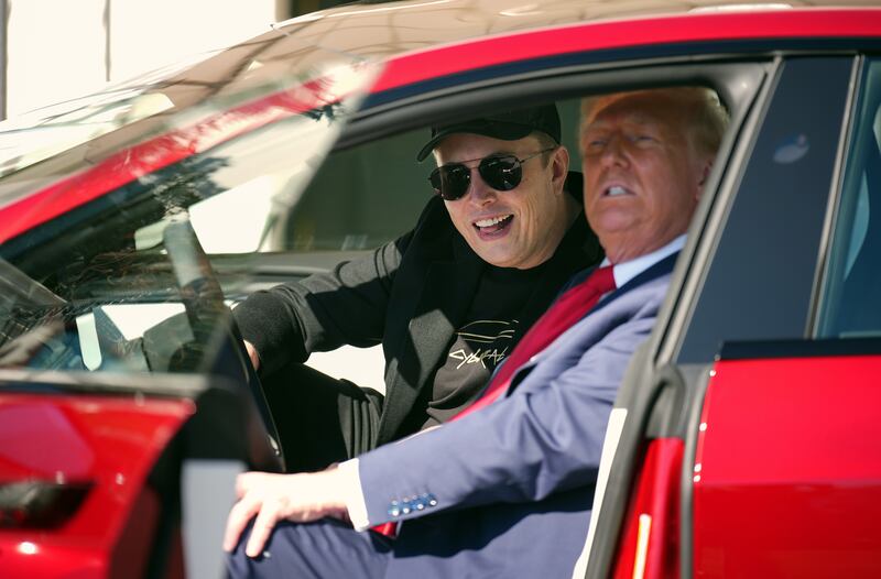 President Donald Trump and Elon Musk sit in a Tesla on the South Lawn of the White House.