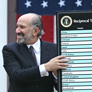 Howard Lutnick holds up cardboard showing tariffs.