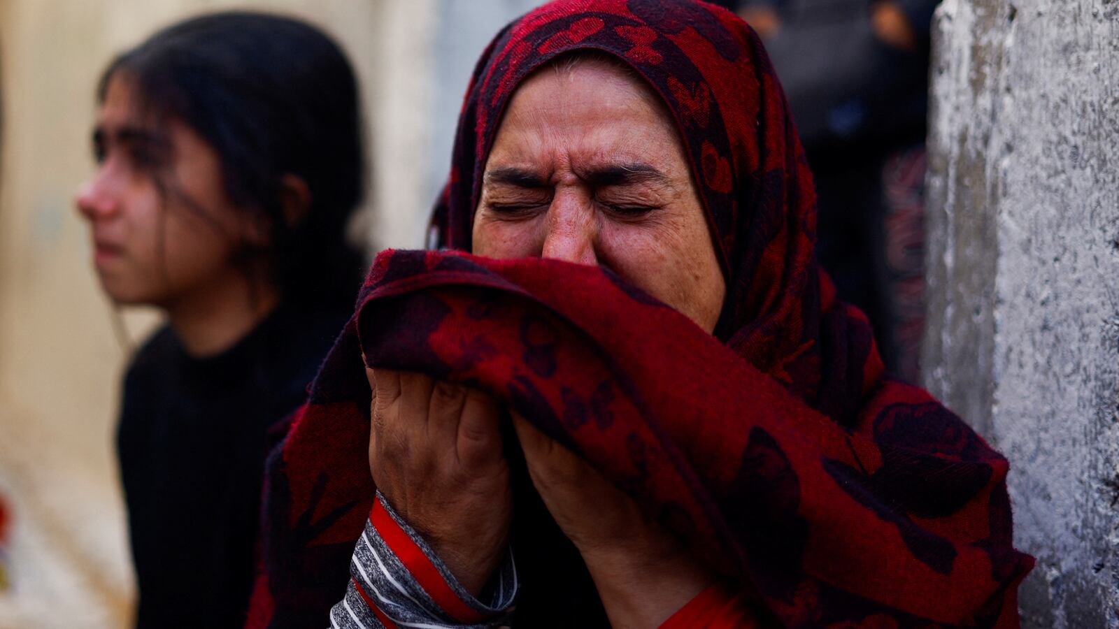A Palestinian woman reacts at the site of an Israeli strike on a house, after a temporary truce between Hamas and Israel expired, in Khan Younis in the southern Gaza Strip